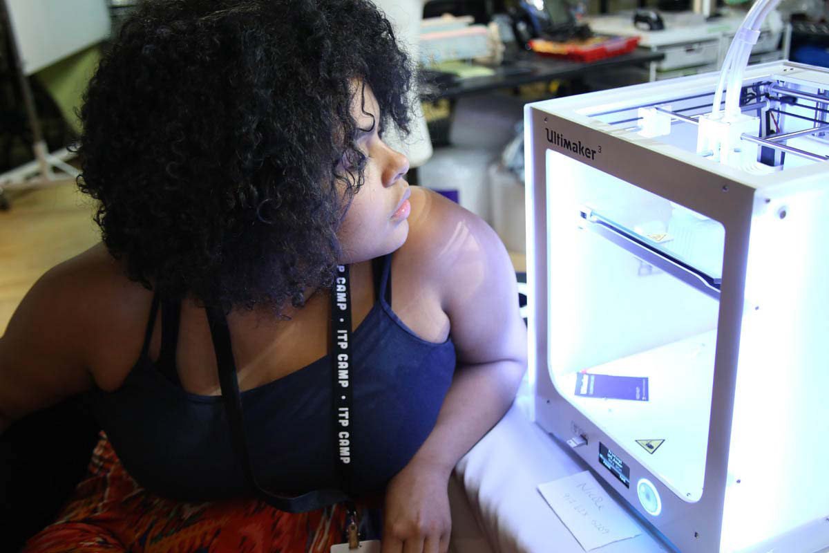 a woman watching her 3D printing project